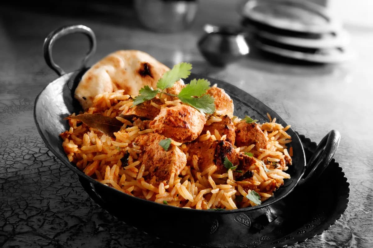 Biryani served in a karahi with naan